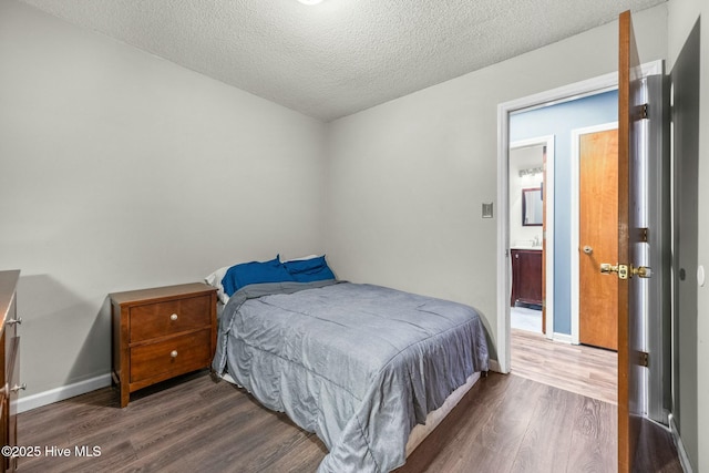 bedroom with dark hardwood / wood-style floors and a textured ceiling