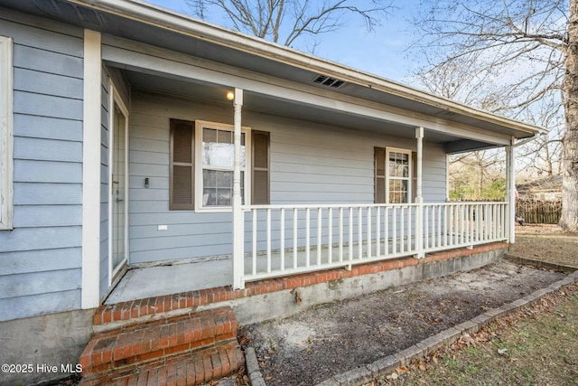 view of side of property featuring covered porch