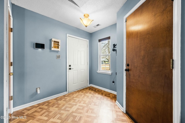 doorway to outside with light parquet floors and a textured ceiling