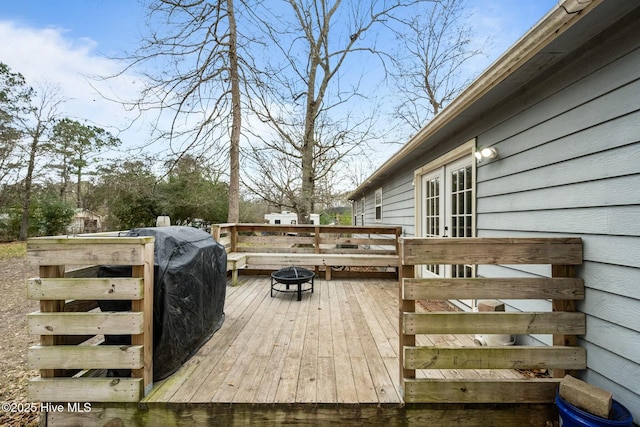 wooden terrace featuring french doors and an outdoor fire pit