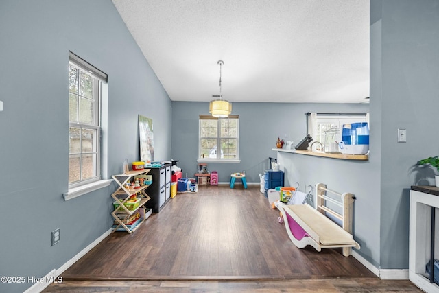 playroom with dark hardwood / wood-style floors and a textured ceiling