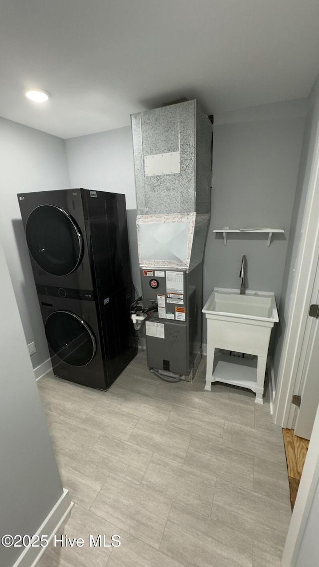 laundry room with stacked washer / dryer and heating unit