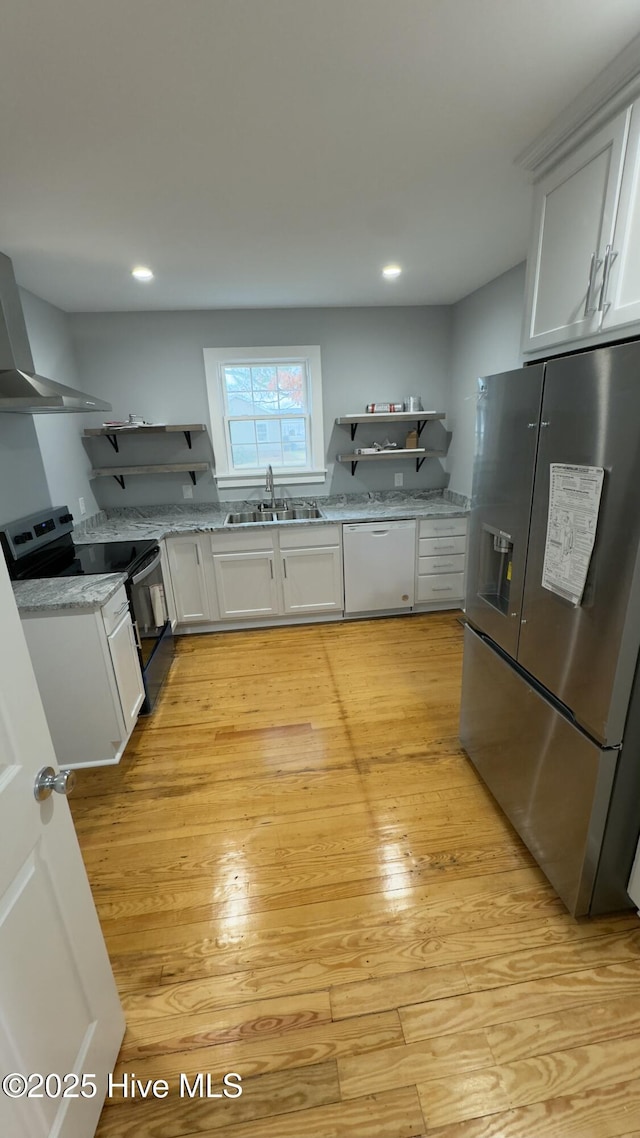 kitchen featuring stainless steel refrigerator with ice dispenser, sink, white cabinetry, electric range, and dishwasher