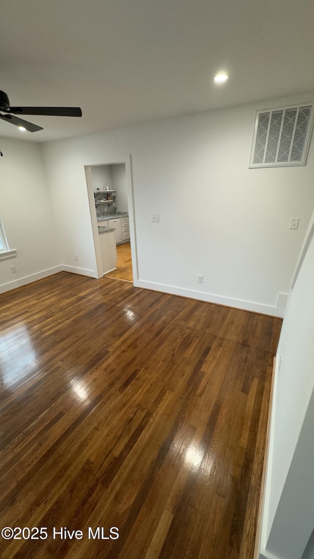 empty room with ceiling fan and dark hardwood / wood-style floors