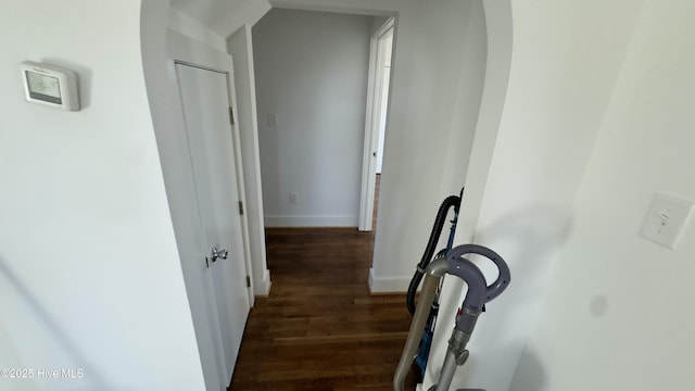 corridor featuring vaulted ceiling and dark wood-type flooring