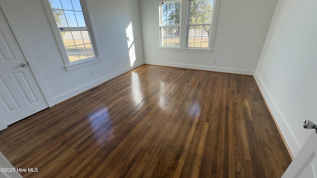 unfurnished room with dark hardwood / wood-style flooring