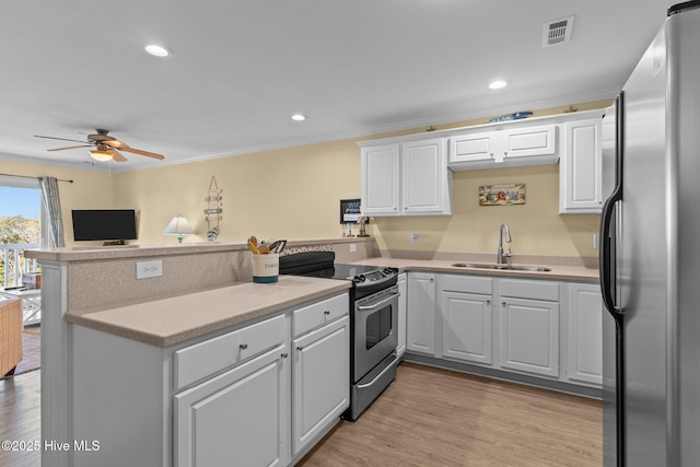 kitchen featuring sink, crown molding, appliances with stainless steel finishes, white cabinetry, and kitchen peninsula