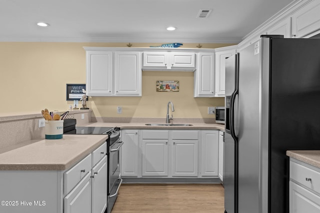 kitchen featuring sink, white cabinets, and appliances with stainless steel finishes