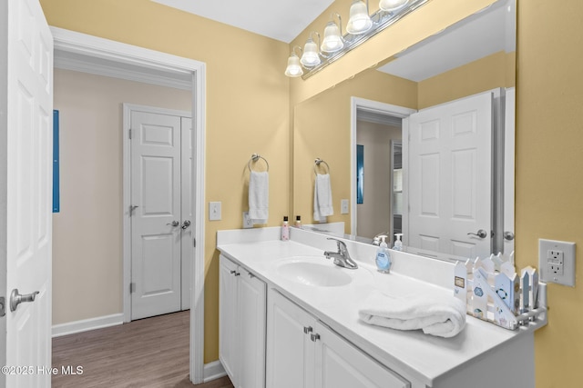 bathroom featuring vanity, hardwood / wood-style floors, and crown molding