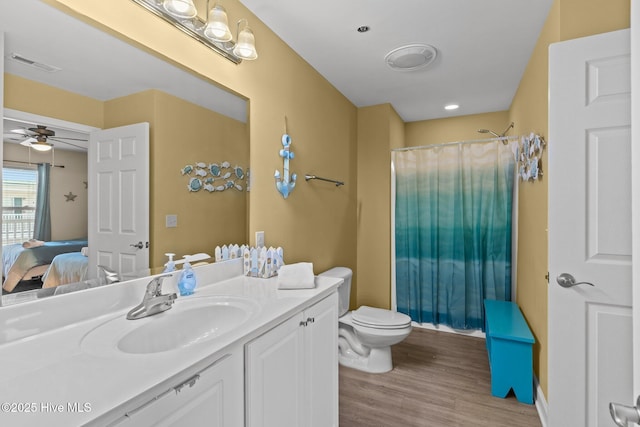 bathroom with wood-type flooring, vanity, ceiling fan, toilet, and a shower with curtain