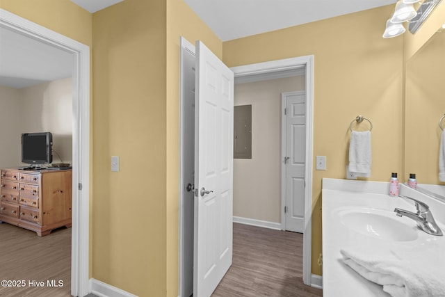 bathroom featuring hardwood / wood-style flooring, vanity, and electric panel