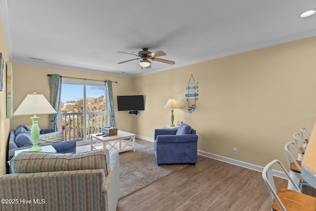 living room with wood-type flooring, ornamental molding, and ceiling fan