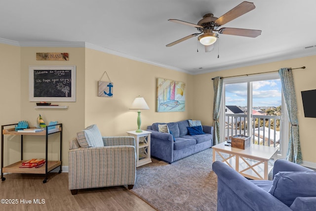 living room featuring ornamental molding, ceiling fan, and light wood-type flooring