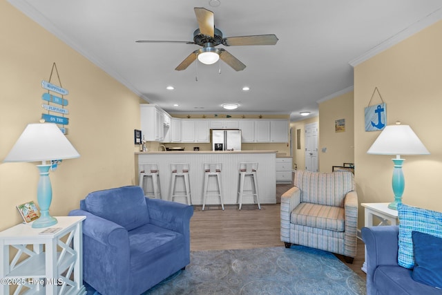 living room with ceiling fan, ornamental molding, and dark hardwood / wood-style floors