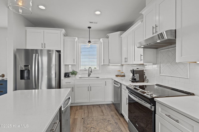 kitchen featuring pendant lighting, white cabinetry, stainless steel appliances, and sink