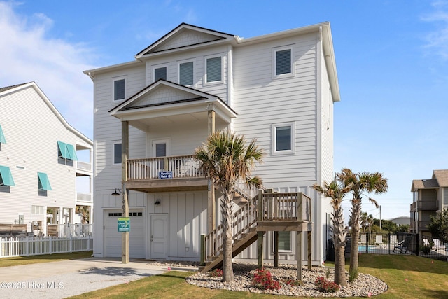 1903 Emerald Dr, Emerald Isle, NC 28594 - rear view of property with fence, stairway, driveway, board and batten siding, and a garage