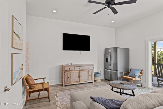 living room featuring light hardwood / wood-style flooring and ceiling fan