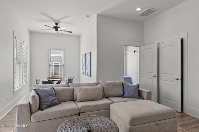 living room featuring ceiling fan and light hardwood / wood-style floors