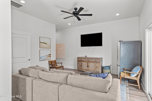 living room with light hardwood / wood-style floors and ceiling fan