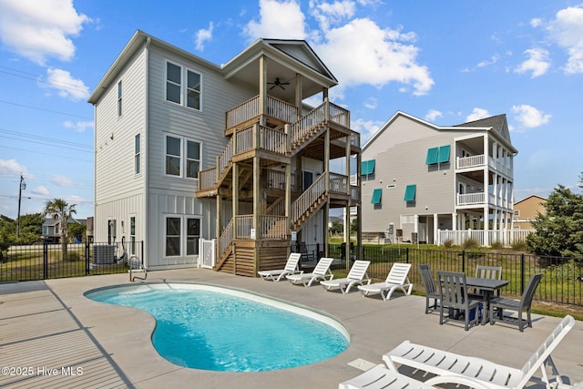 back of property with ceiling fan, a fenced in pool, a balcony, and a patio area