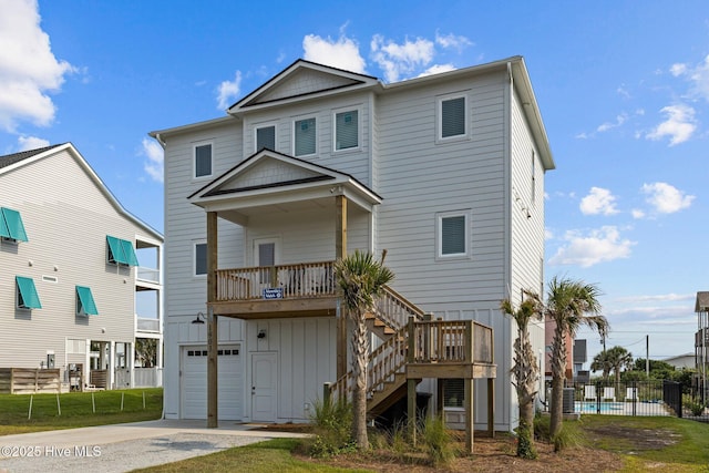1903 Emerald Dr, Emerald Isle, NC 28594 - rear view of house featuring board and batten siding, fence, a garage, driveway, and stairs