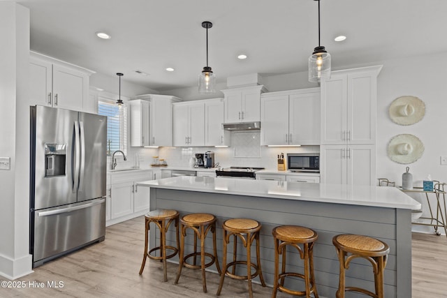 kitchen featuring stainless steel appliances, white cabinetry, and a kitchen island