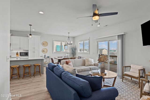 living room featuring ceiling fan and light hardwood / wood-style floors