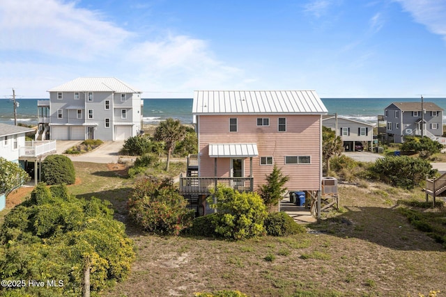 1903 Emerald Dr, Emerald Isle, NC 28594 - back of property with metal roof, central AC unit, a garage, and a deck with water view
