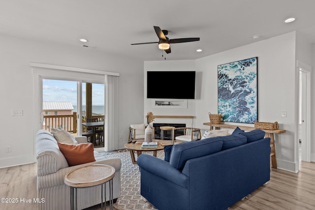 living room with ceiling fan and light hardwood / wood-style flooring