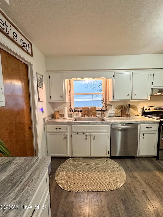 kitchen featuring sink, a textured ceiling, appliances with stainless steel finishes, dark hardwood / wood-style flooring, and white cabinets