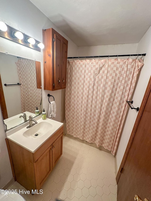 bathroom featuring walk in shower and vanity