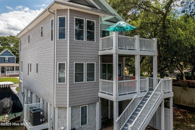 view of side of home featuring a balcony and central AC unit