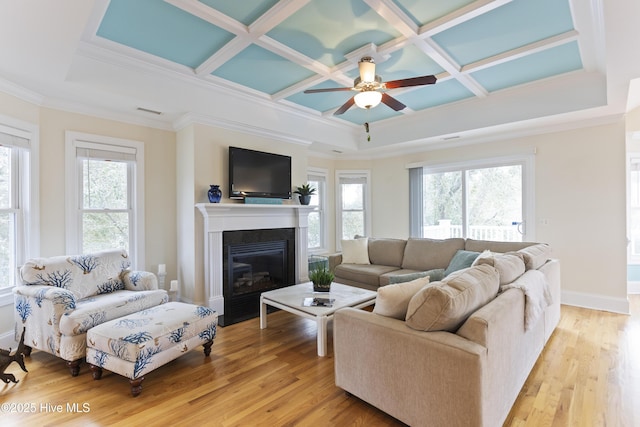 living room with coffered ceiling, a healthy amount of sunlight, and light wood-type flooring