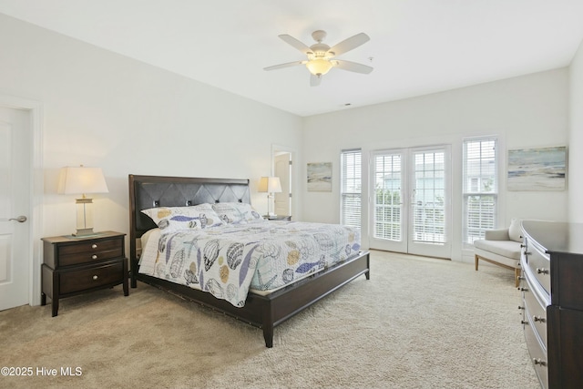 bedroom with access to outside, light colored carpet, and ceiling fan