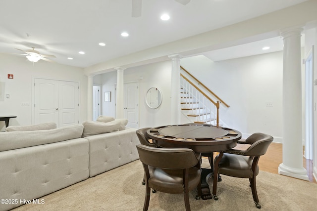 dining room with decorative columns, ceiling fan, and light hardwood / wood-style floors