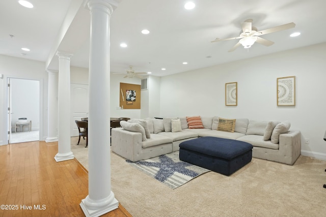 living room featuring ornate columns, light wood-type flooring, and ceiling fan