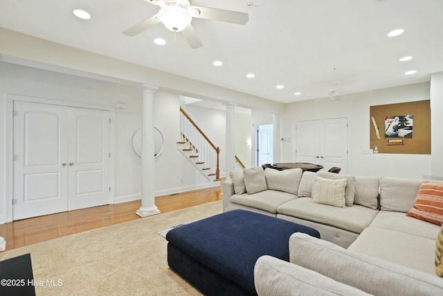 living room with decorative columns, hardwood / wood-style flooring, and ceiling fan