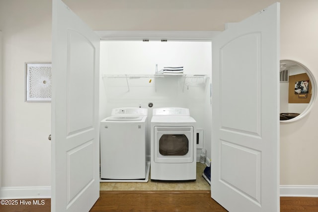 laundry room featuring hardwood / wood-style flooring and washing machine and dryer