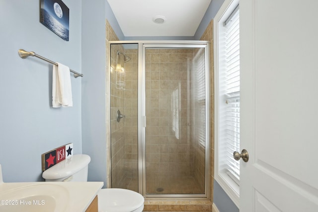 bathroom featuring toilet, vanity, and walk in shower