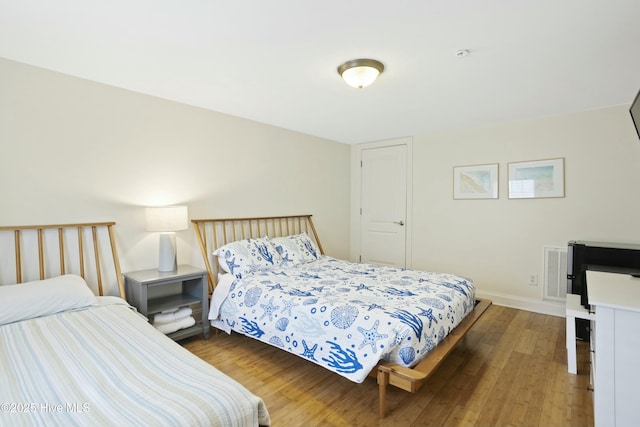 bedroom with dark hardwood / wood-style floors