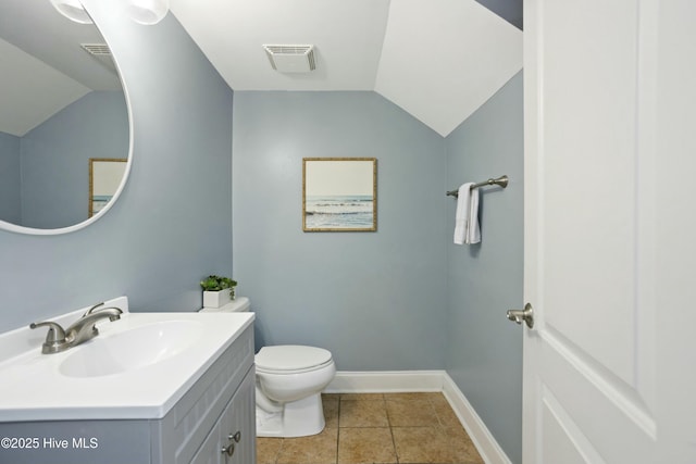 bathroom featuring tile patterned floors, lofted ceiling, toilet, and vanity