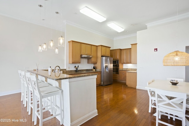 kitchen with pendant lighting, dark stone counters, ornamental molding, kitchen peninsula, and stainless steel appliances