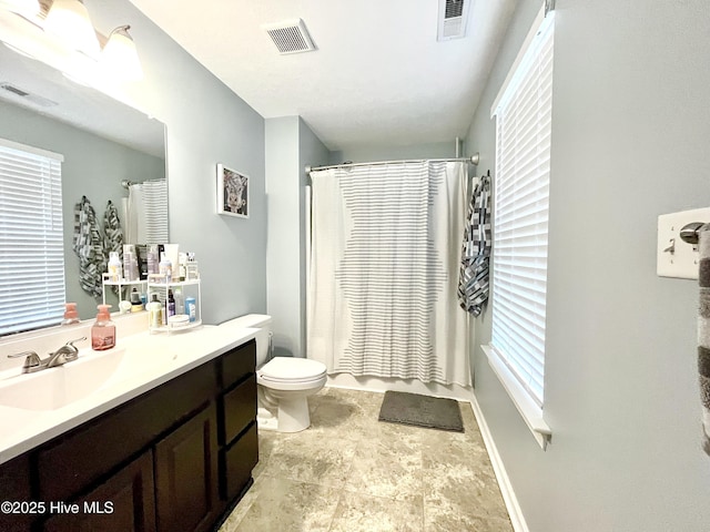 bathroom featuring vanity, toilet, and curtained shower