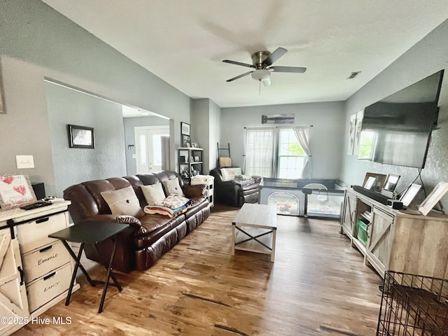 living room with wood-type flooring and ceiling fan