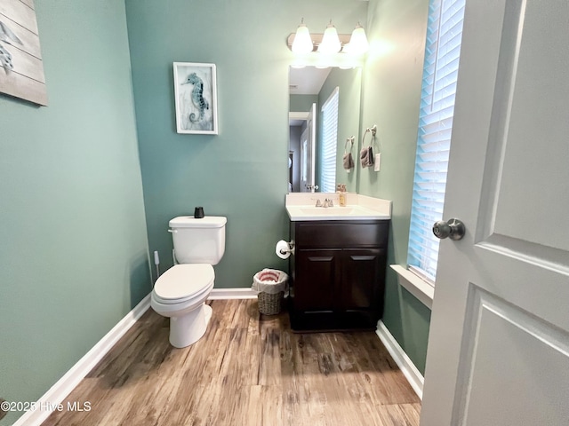 bathroom with wood-type flooring, vanity, and toilet