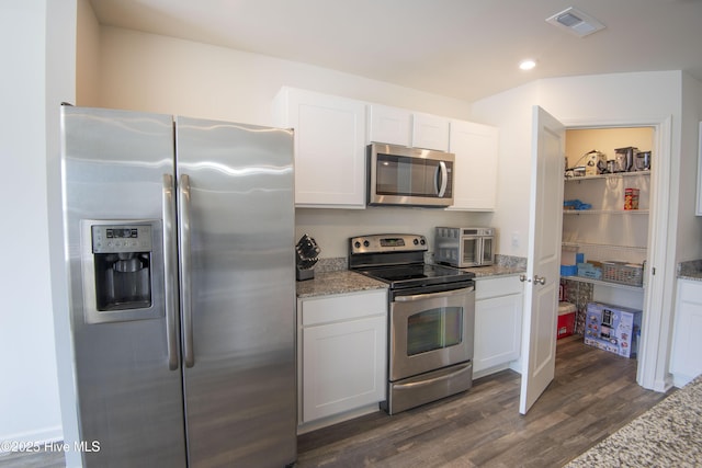 kitchen with light stone counters, white cabinets, and appliances with stainless steel finishes