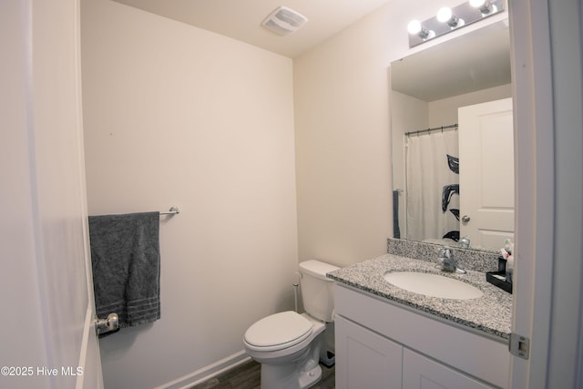 bathroom featuring vanity, hardwood / wood-style floors, and toilet