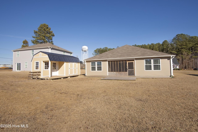 rear view of house with a yard and a shed