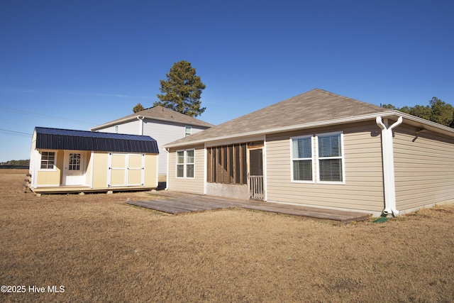 back of house with a lawn and a storage shed