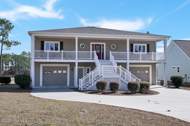 raised beach house featuring a garage and covered porch